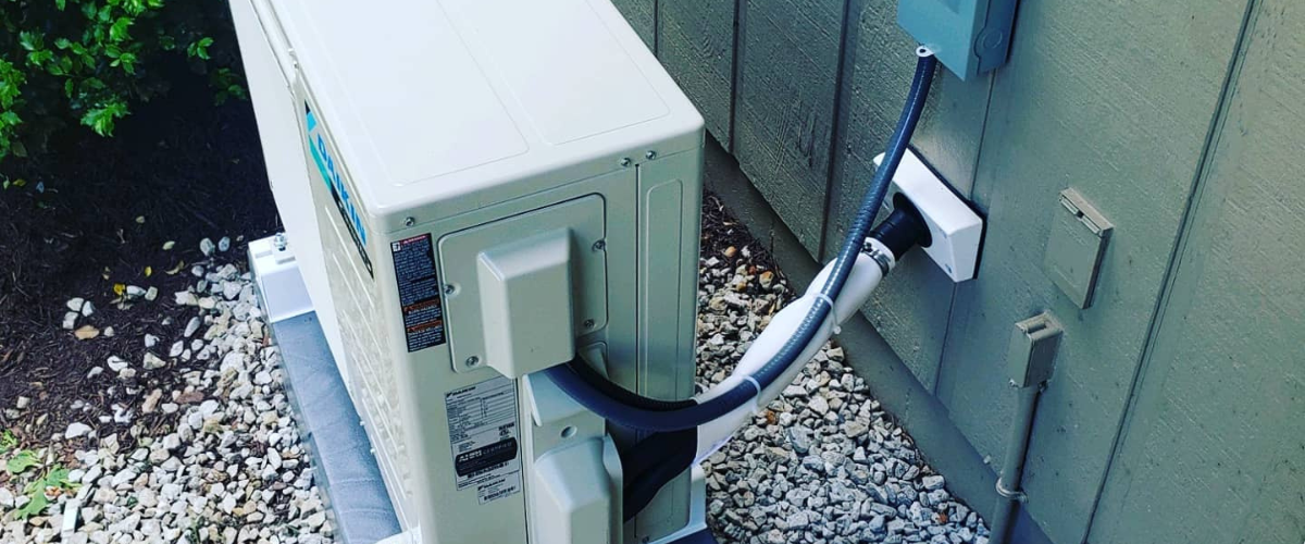 A Daikin heat pump pictured plugged into outdoor wall